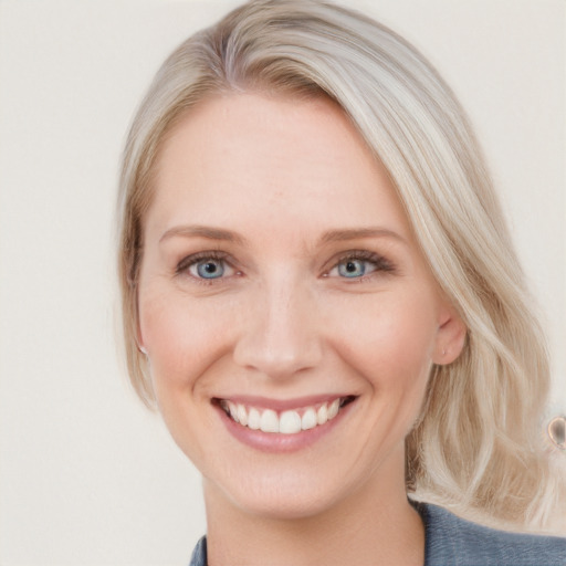 Joyful white young-adult female with medium  brown hair and blue eyes