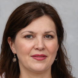 Joyful white adult female with long  brown hair and grey eyes