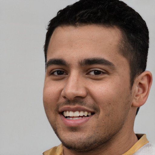 Joyful white young-adult male with short  black hair and brown eyes