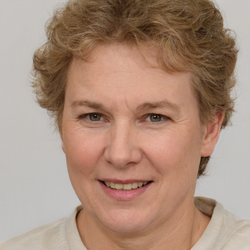 Joyful white adult female with short  brown hair and blue eyes