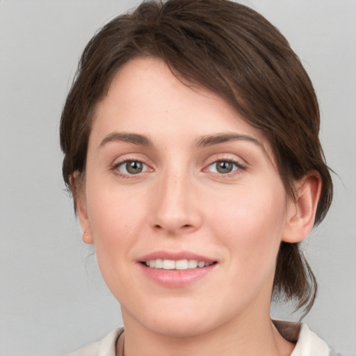 Joyful white young-adult female with medium  brown hair and grey eyes