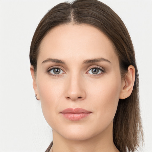 Joyful white young-adult female with long  brown hair and grey eyes