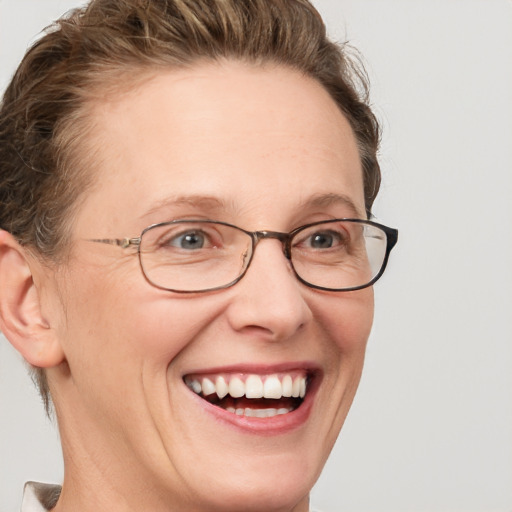 Joyful white adult female with short  brown hair and blue eyes