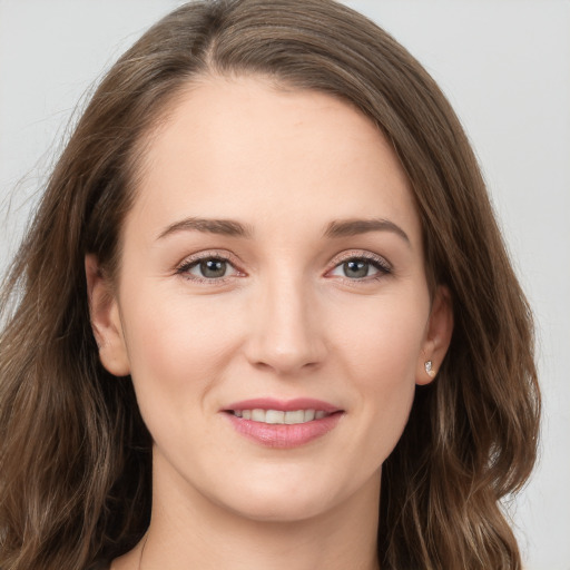 Joyful white young-adult female with long  brown hair and grey eyes