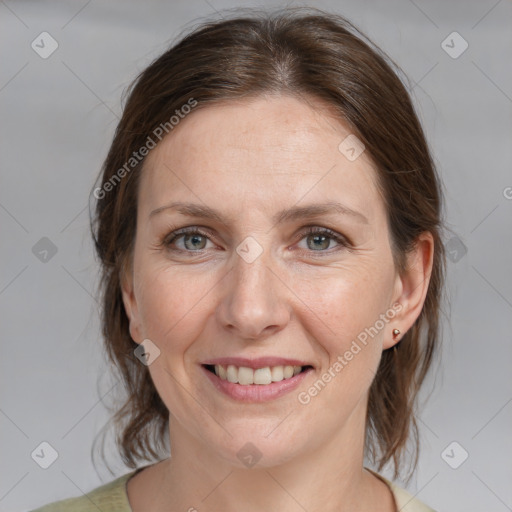 Joyful white adult female with medium  brown hair and grey eyes