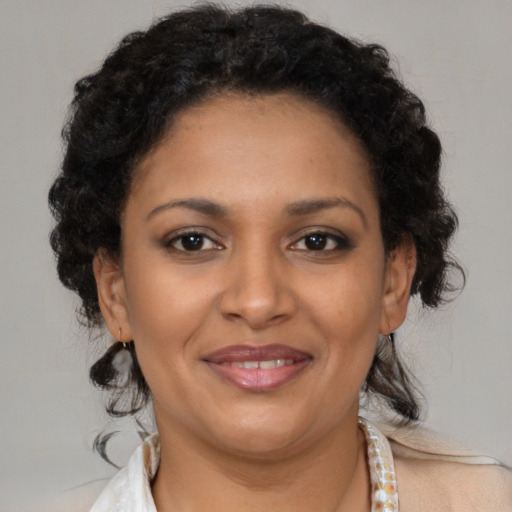 Joyful black adult female with medium  brown hair and brown eyes