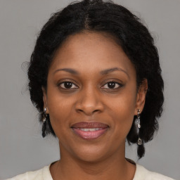 Joyful black adult female with medium  brown hair and brown eyes