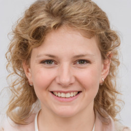 Joyful white young-adult female with medium  brown hair and blue eyes