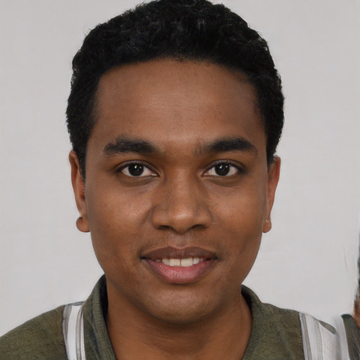 Joyful black young-adult male with short  black hair and brown eyes