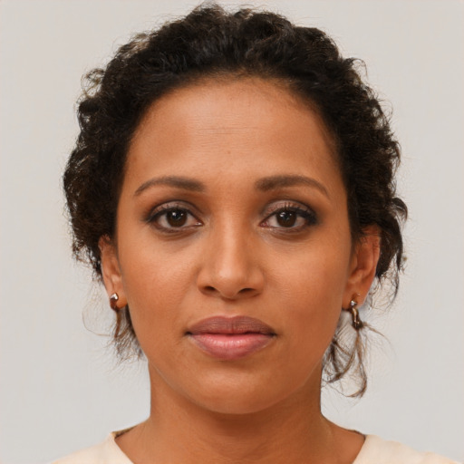 Joyful black young-adult female with short  brown hair and brown eyes