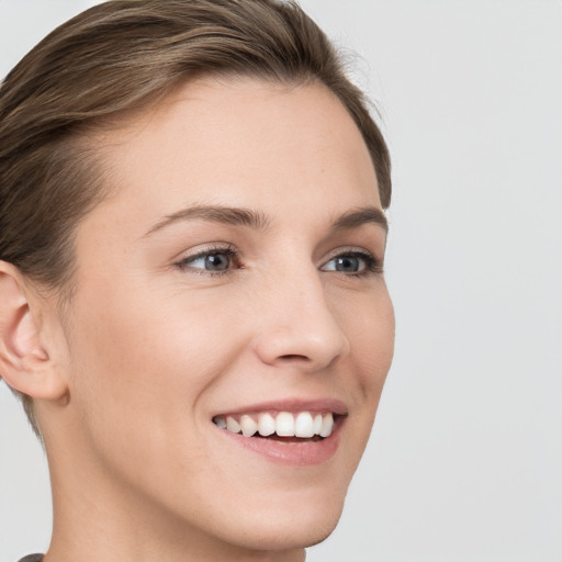 Joyful white young-adult female with short  brown hair and grey eyes