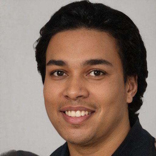 Joyful latino young-adult male with short  black hair and brown eyes