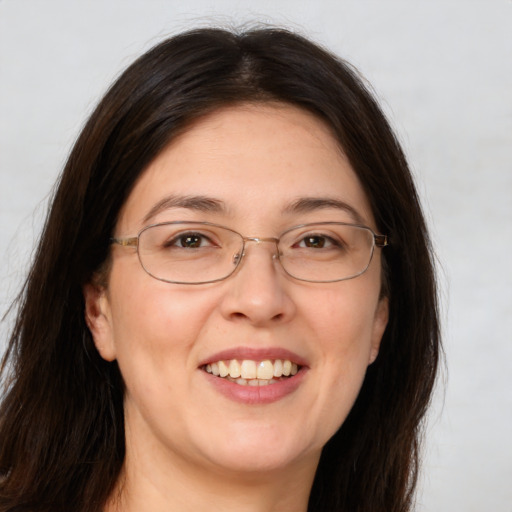 Joyful white adult female with long  brown hair and brown eyes