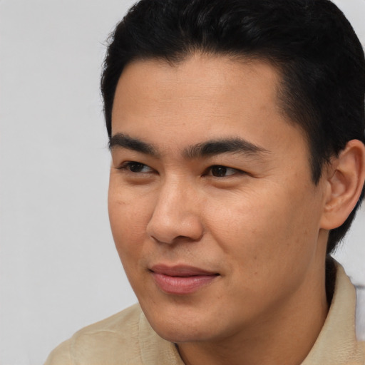 Joyful asian young-adult male with short  black hair and brown eyes
