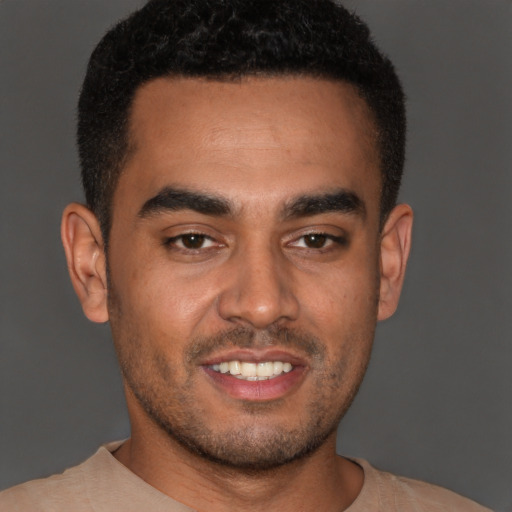 Joyful latino young-adult male with short  brown hair and brown eyes
