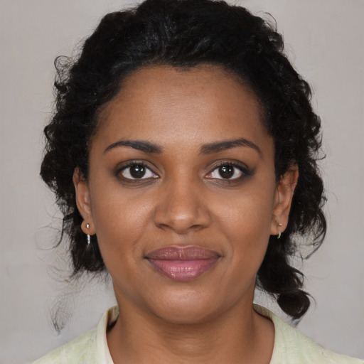 Joyful black young-adult female with medium  black hair and brown eyes