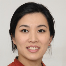 Joyful asian young-adult female with medium  black hair and brown eyes