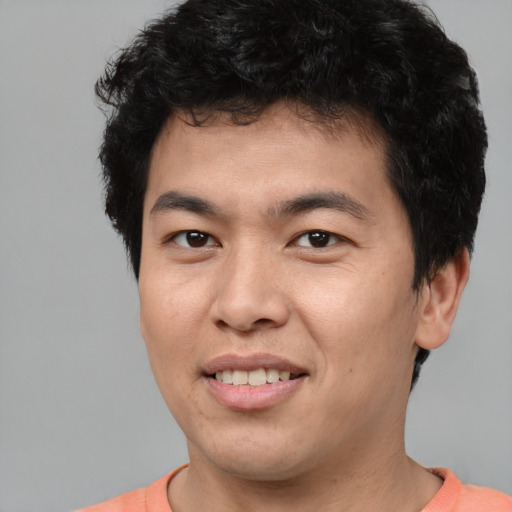 Joyful asian young-adult male with short  black hair and brown eyes