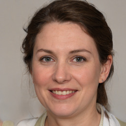 Joyful white adult female with medium  brown hair and blue eyes