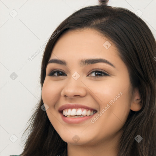 Joyful latino young-adult female with long  black hair and brown eyes