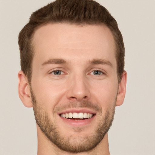 Joyful white young-adult male with short  brown hair and grey eyes