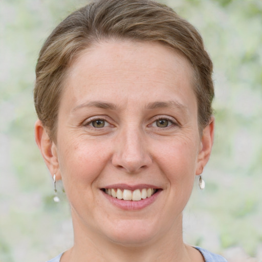 Joyful white young-adult female with short  brown hair and green eyes