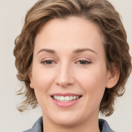 Joyful white young-adult female with medium  brown hair and green eyes