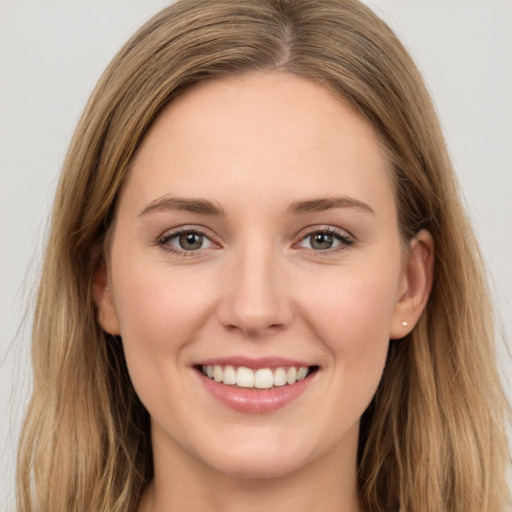 Joyful white young-adult female with long  brown hair and grey eyes