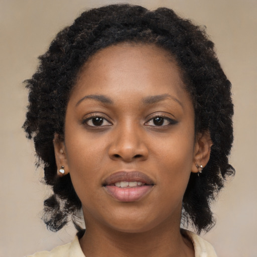 Joyful black young-adult female with long  brown hair and brown eyes
