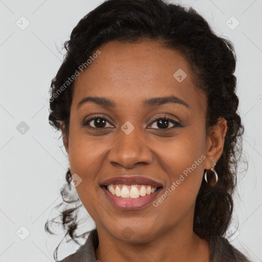 Joyful black young-adult female with long  brown hair and brown eyes