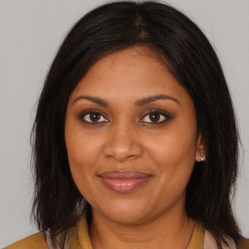 Joyful black young-adult female with long  brown hair and brown eyes