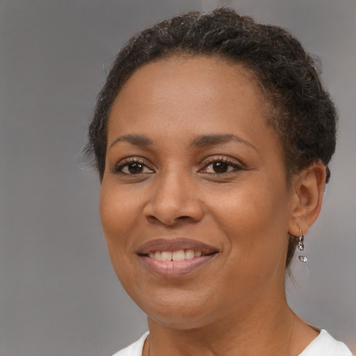 Joyful black young-adult female with short  brown hair and brown eyes