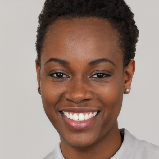 Joyful black young-adult female with short  brown hair and brown eyes