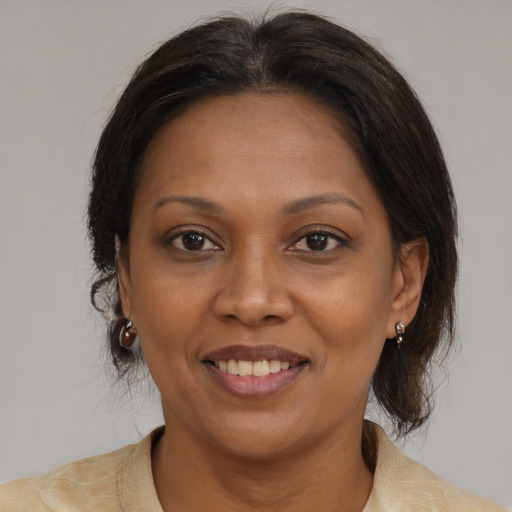 Joyful black adult female with medium  brown hair and brown eyes