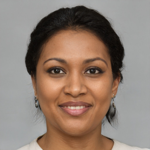 Joyful black young-adult female with medium  brown hair and brown eyes