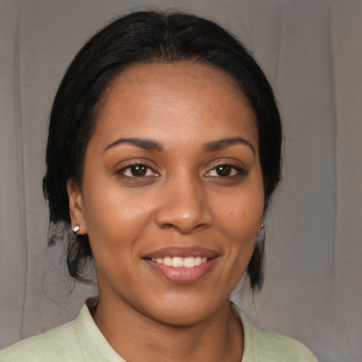 Joyful black young-adult female with medium  brown hair and brown eyes