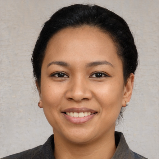 Joyful latino young-adult female with short  black hair and brown eyes