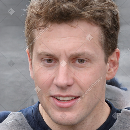 Joyful white adult male with short  brown hair and grey eyes