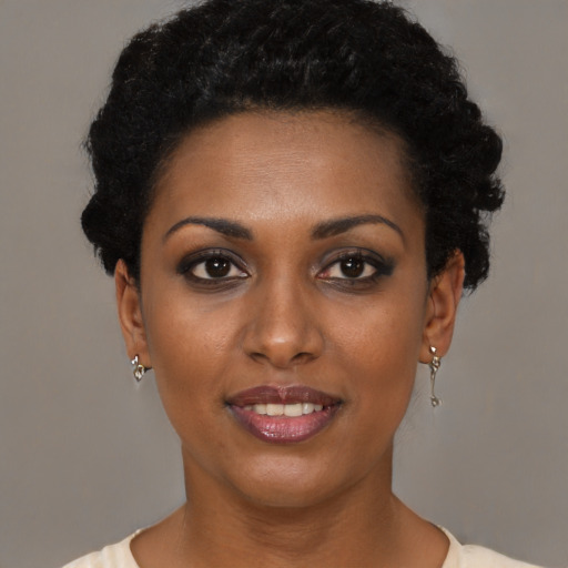 Joyful black young-adult female with short  brown hair and brown eyes