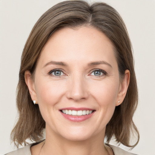 Joyful white young-adult female with medium  brown hair and grey eyes