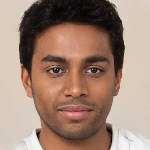 Joyful black young-adult male with short  brown hair and brown eyes