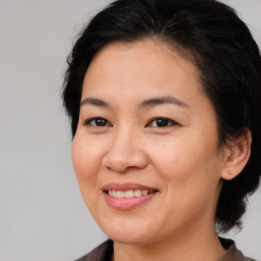 Joyful asian adult female with medium  brown hair and brown eyes