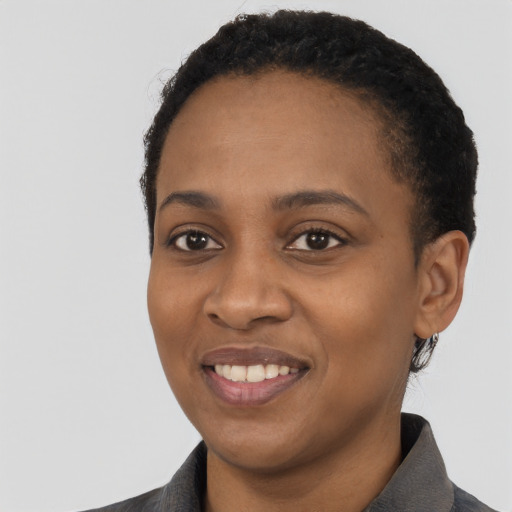 Joyful black young-adult female with short  black hair and brown eyes