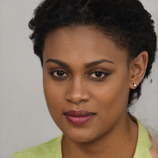 Joyful black young-adult female with short  brown hair and brown eyes