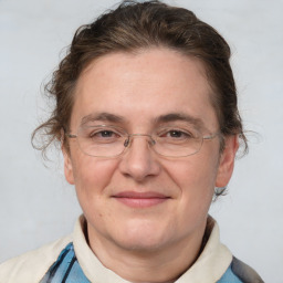 Joyful white adult female with medium  brown hair and blue eyes