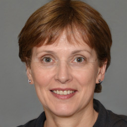 Joyful white adult female with medium  brown hair and grey eyes