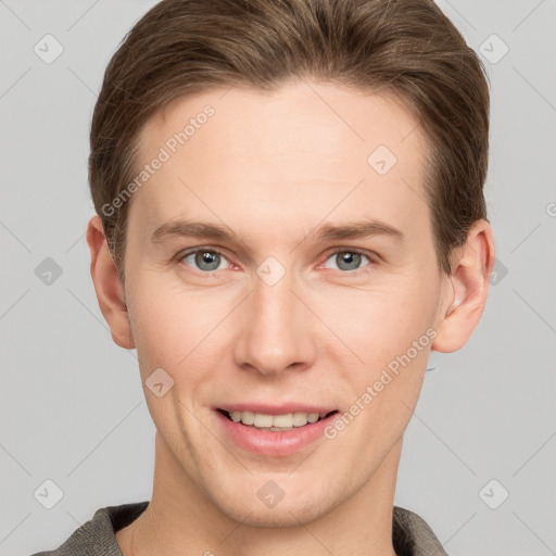 Joyful white young-adult male with short  brown hair and grey eyes