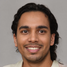 Joyful latino young-adult male with short  brown hair and brown eyes