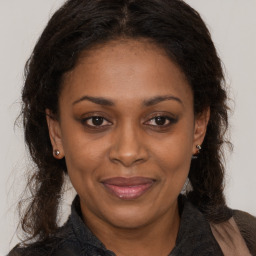 Joyful black adult female with long  brown hair and brown eyes