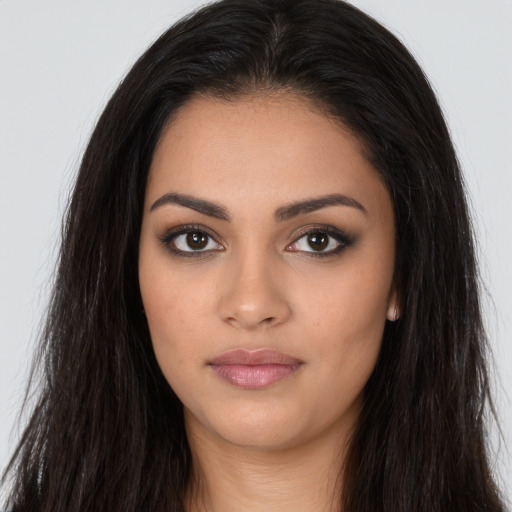 Joyful latino young-adult female with long  brown hair and brown eyes